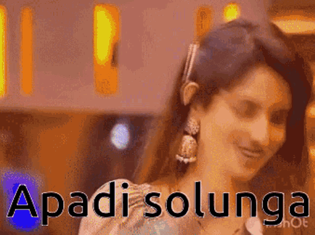 a woman wearing earrings is smiling with the words apadi solunga behind her