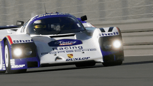 a white and blue racing car with dunlop written on the side
