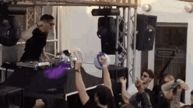 a dj is playing music to a crowd of people