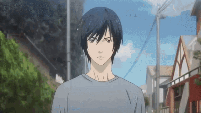 a man with long black hair is standing in front of a row of houses .