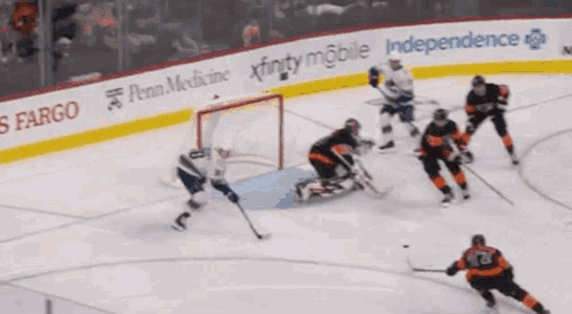 a hockey game is being played sponsored by penn medicine xfinity mobile and independence