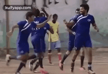 a group of soccer players are running and celebrating a goal on a field .
