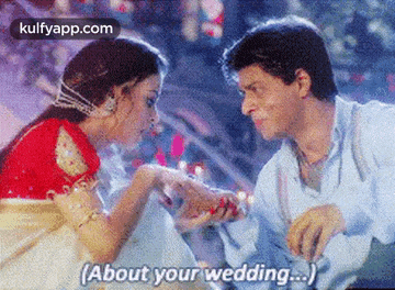 a man is putting a ring on a woman 's finger and says `` about your wedding . ''