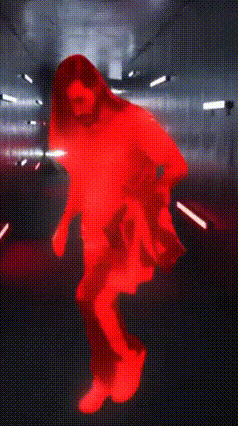 a person is dancing in a dark room with a red light behind them .