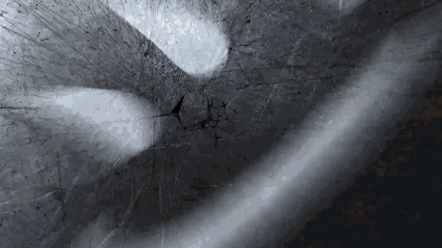 a close up of a person 's hand on a broken glass window .