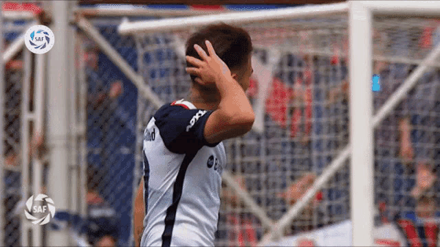 a soccer player is covering his ears with his hand and the word saf is on the bottom of the screen