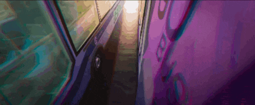 a narrow hallway with purple walls and a purple light