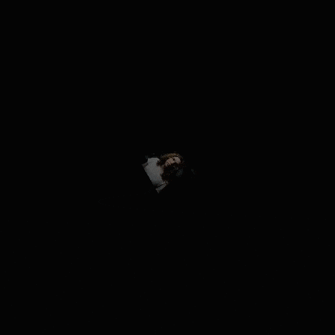 a woman with long curly hair and a white shirt laying down
