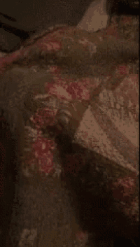 a blanket with flowers on it is laying on a bed
