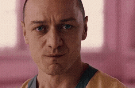 a close up of a man 's face with a serious look on his face in a pink room .