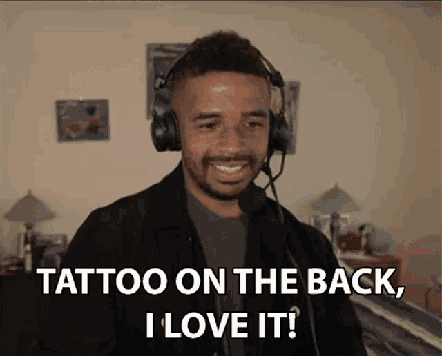 a man wearing headphones is saying " tattoo on the back i love it "
