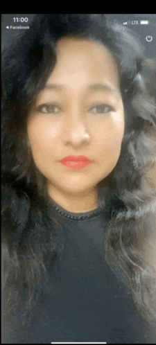 a woman 's face is displayed on a phone screen with the time 11:00 on it