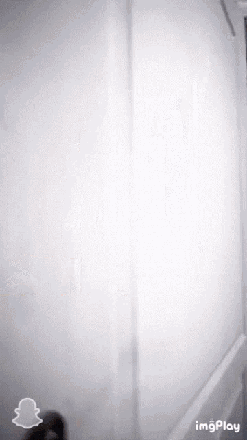 a woman is standing in a doorway with a snapchat logo on the bottom right
