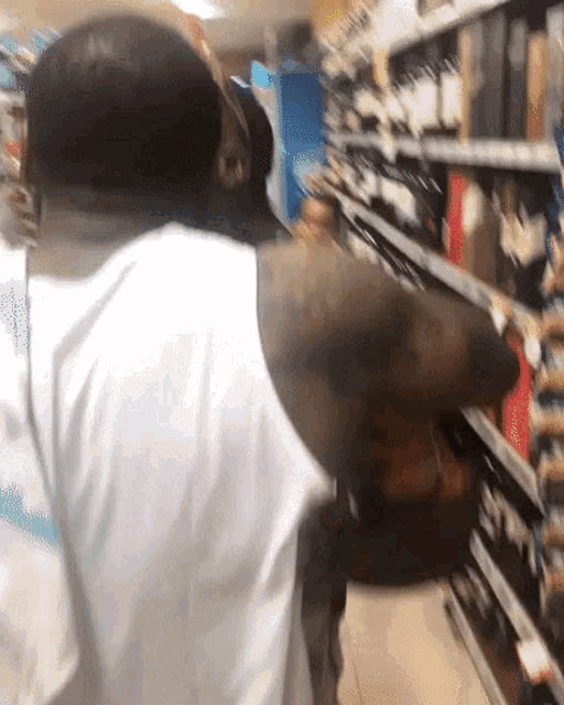 a man in a white shirt is standing in front of a shelf in a store
