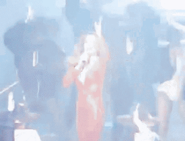 a woman in a red dress is singing into a microphone on stage