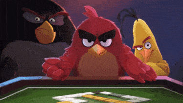 three angry birds are playing a game of dominoes on a table