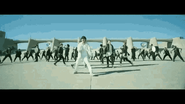 a group of people are dancing on a street in a video .