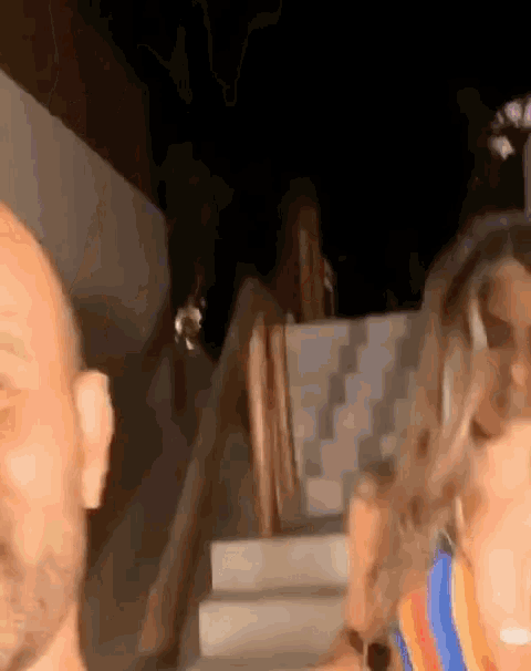a man and a woman are standing next to each other at night .