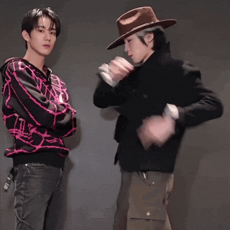 a man wearing a hat talks to another man