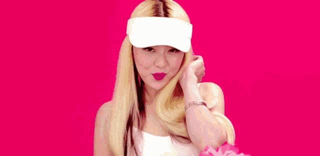 a blonde woman wearing a white visor and a white tank top