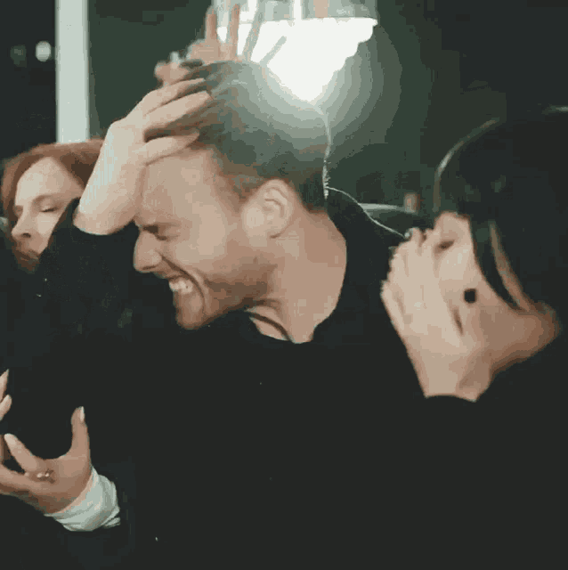 a group of people are standing next to each other in a dark room .