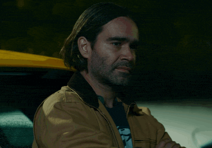 a man with long hair and a beard is sitting in a car