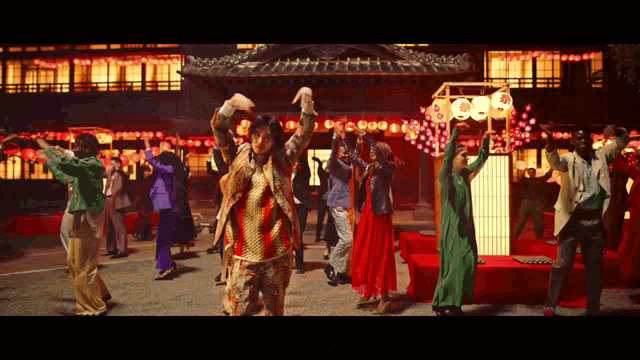 a group of people are dancing in front of a building that has a sign that says ' 000 ' on it