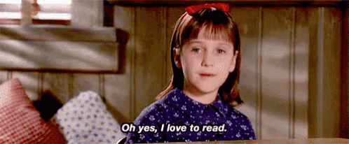 a little girl is sitting at a table and says `` oh yes , i love to read '' .