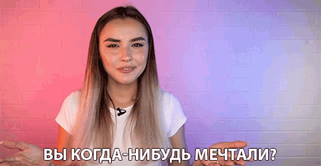 a woman in a white shirt with a microphone on her neck is talking in russian