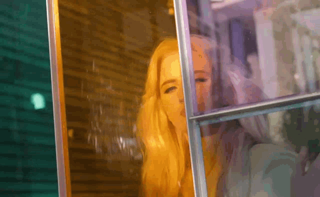 a woman is looking out of a window at night