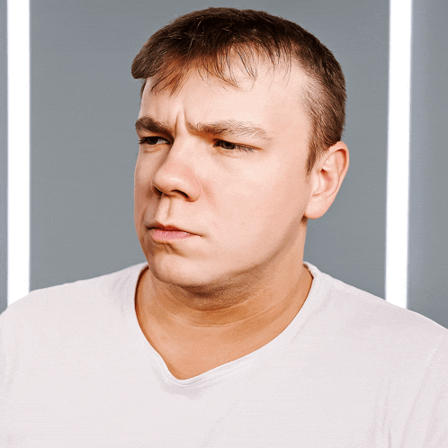 a man in a white shirt is making a face