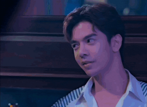 a young man in a striped shirt is looking at the camera