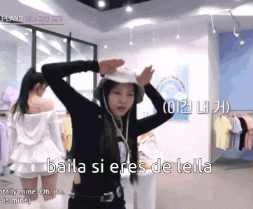 a woman wearing a bucket hat with the words baila si eres de leila written below her
