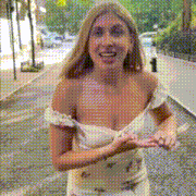 a woman in a white dress is walking down a street .