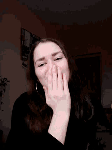 a woman wearing red lipstick and hoop earrings is making a funny face