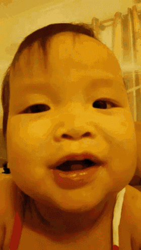 a close up of a baby 's face with a yellow background