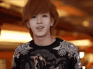 a young man with red hair is wearing a black sweater with rhinestones on the sleeves