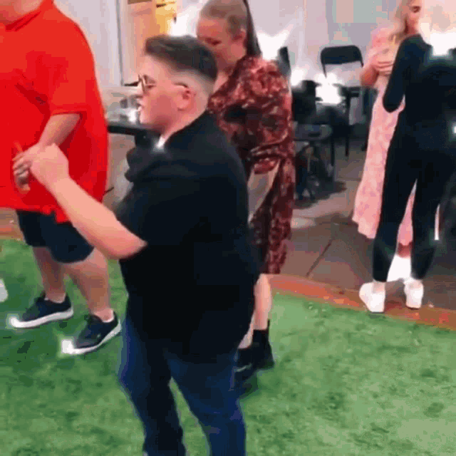 a man in a black shirt is dancing with a woman in a pink dress .