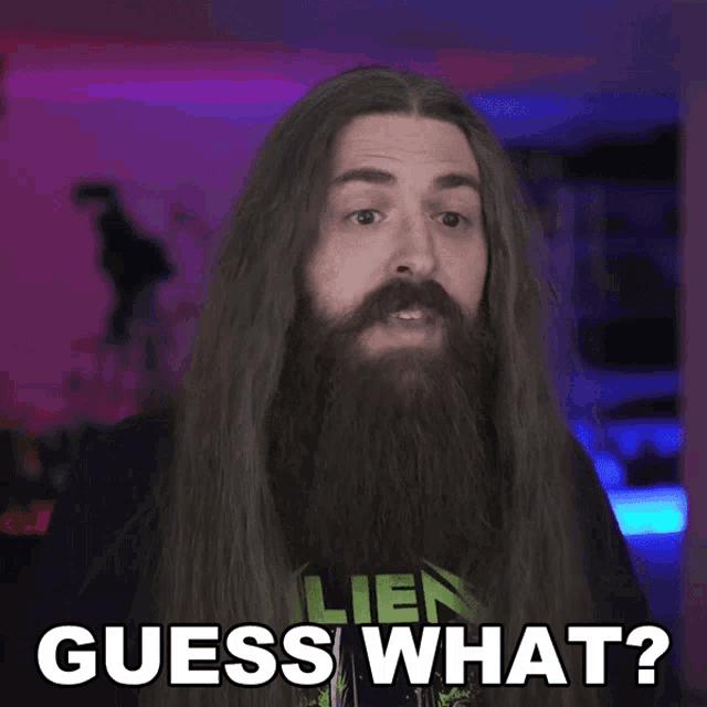 a man with long hair and a beard is wearing a metallica shirt and says guess what