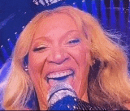 a close up of a woman singing into a microphone .