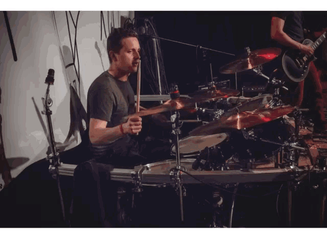 a man playing drums in front of a microphone