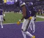 a football player wearing a purple jersey with the number 7 on it is running on the field .