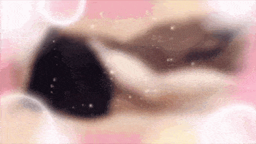 a blurry picture of a person laying on a pink surface with bubbles .