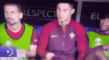 a group of soccer players sitting in a dugout with a sign that says respect