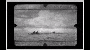 a black and white photo of three boats in the ocean