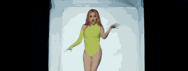 a woman in a neon yellow bodysuit and gloves is dancing in a white box .