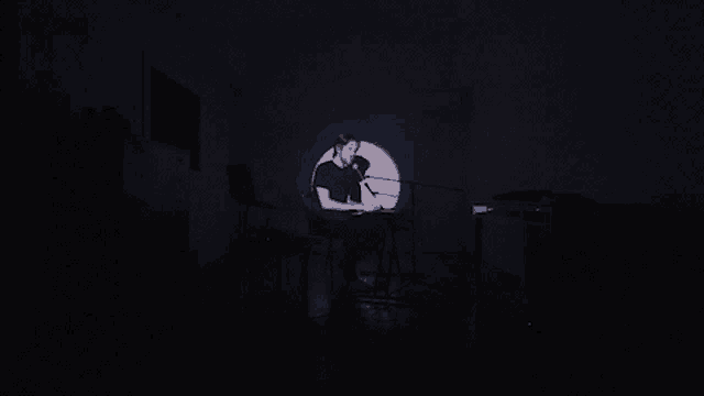 a man singing into a microphone in a dark room with the words " what the fuck is going on " below him