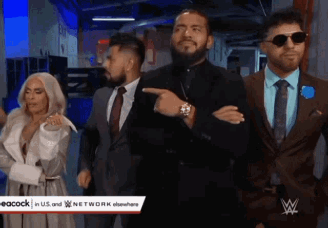 a group of people in suits are standing in a hallway with a peacock logo on the bottom