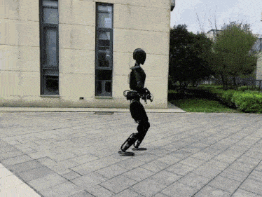 a black robot is walking on a brick sidewalk in front of a building