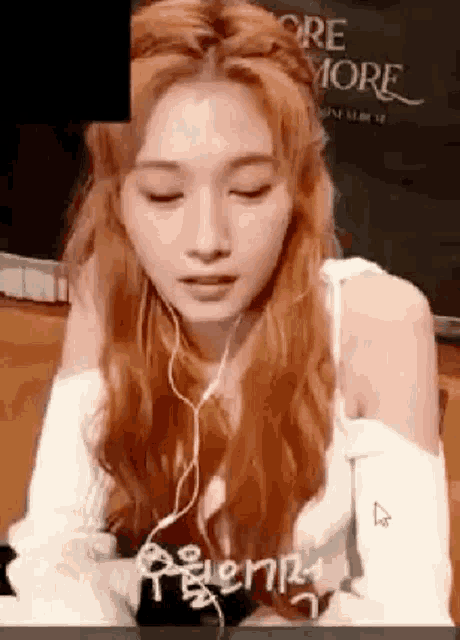 a woman with long red hair is wearing headphones and a white top .